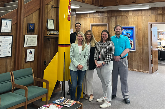 Rep. Pettersen poses with a full sized rocket at Estes Rockets 